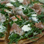 Pizza mit Parmaschinken, Rucola und Parmesan