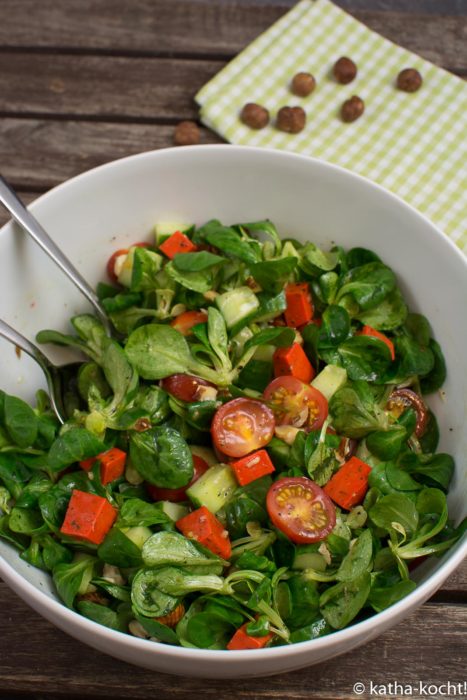 Grüner Salat mit rotem Pestokäse und Nüssen