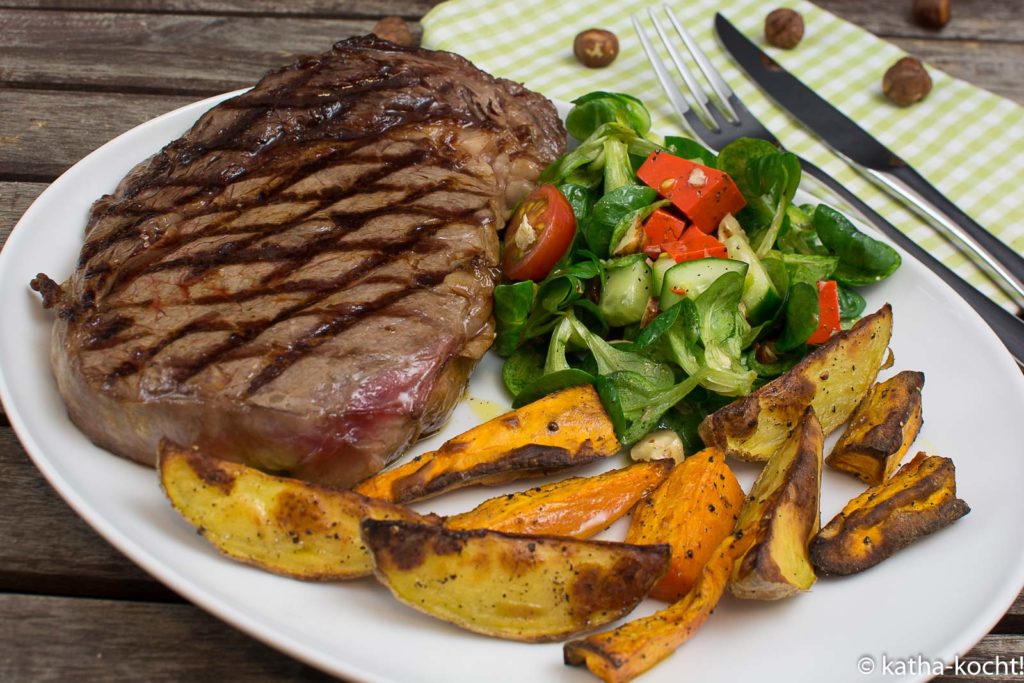 Steak mit zweierlei Kartoffelspalten und Salat mit Pestokäse und Walnüssen