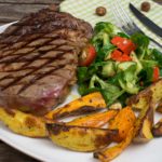 Steak mit zweierlei Kartoffelspalten und Salat mit Pestokäse und Walnüssen