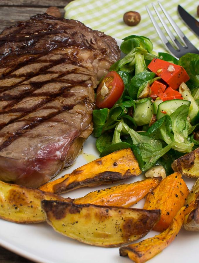 Steak mit zweierlei Kartoffelspalten und Salat mit Pestokäse und Walnüssen