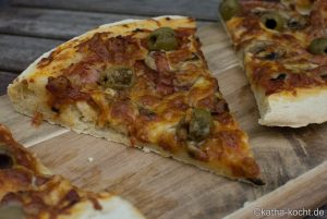 Pizza mit Speck und Oliven