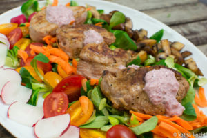Schweinemedaillons mit Pilzen und rotem Dressing auf Salat Schweinemedaillons mit Pilzen und rotem Dressing