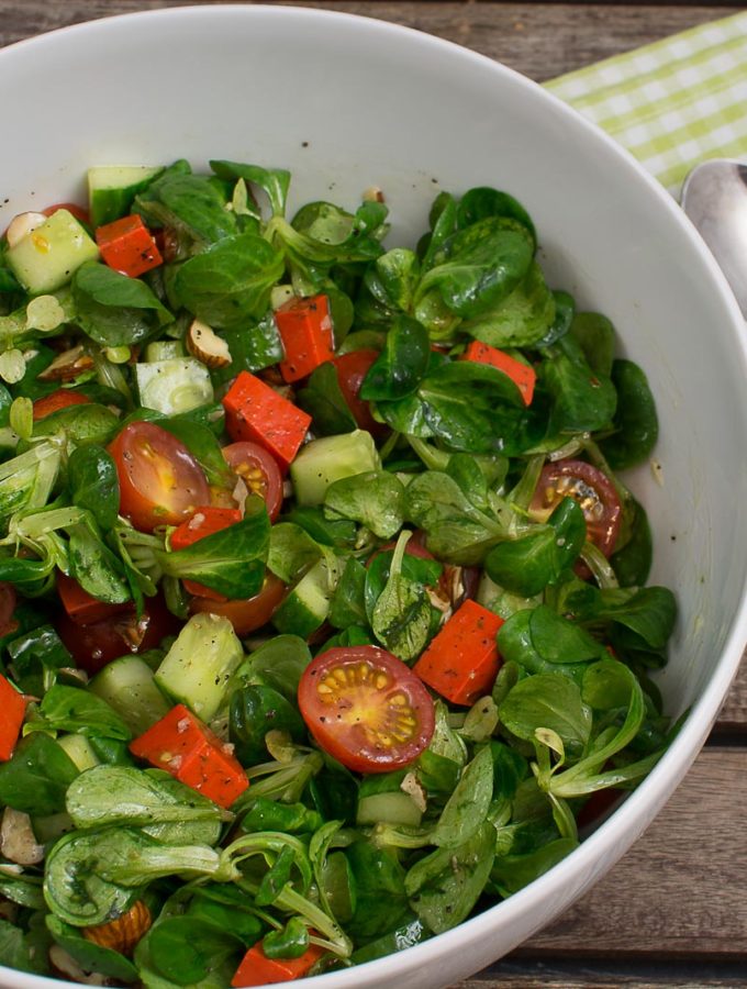 Grüner Salat mit rotem Pestokäse und Nüssen