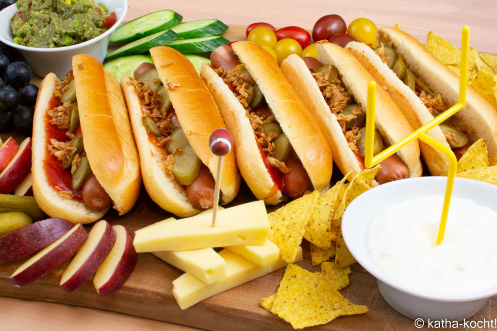 Hot Dog Charcuterieplatte mit  klassischen Hot Dogs, Nachos, Dips, Käse und jeder Menge Obst und Gemüse